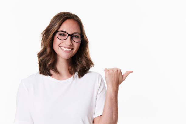 Pointing glasses girl in white studio, portrait